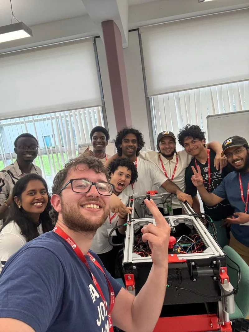 Innova UoL team members grinning in a selfie with their rover INNEX-1