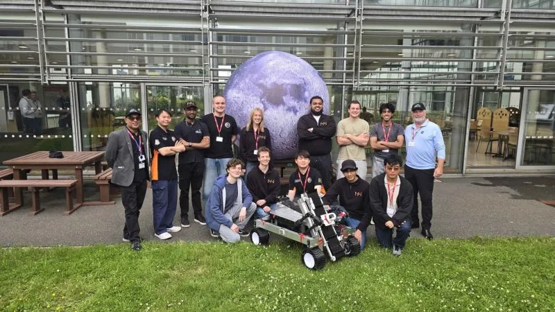 Project MarsWorks team with their rover in front of the inflatable Moon