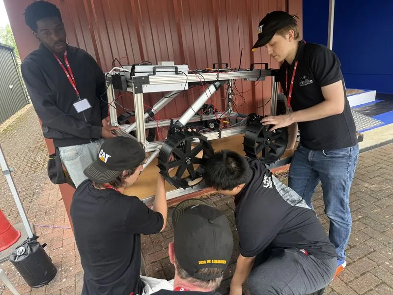 Newcastle Lunabotics students fitting wheels to their rover's frame in the pit