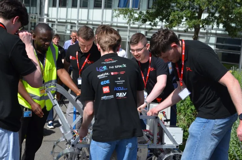 QPL team members gathered around their rover in the pit area